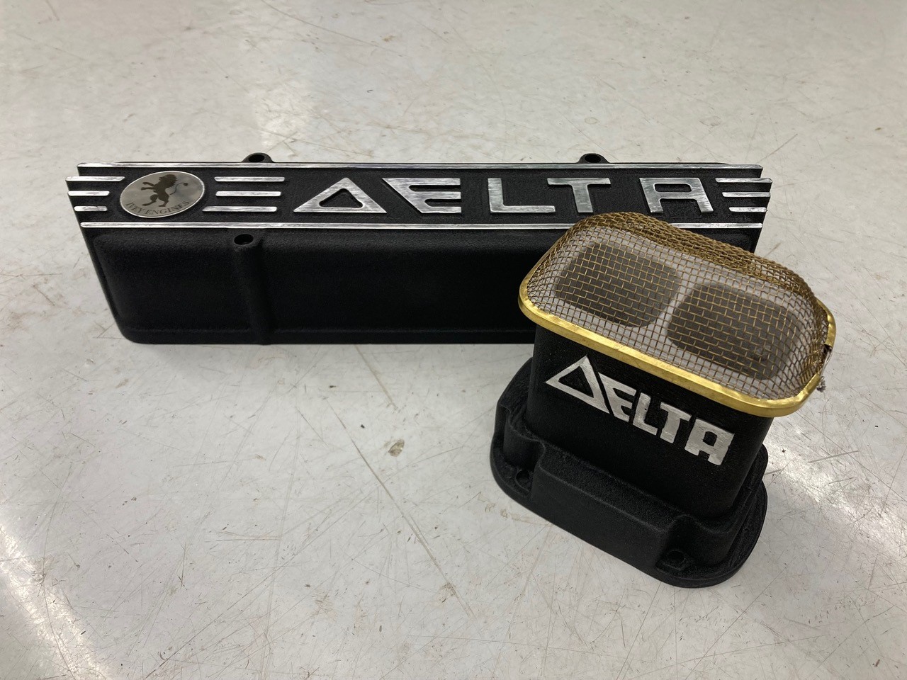 A black and gold rectangular object with a silver logo

Description automatically generated with medium confidence