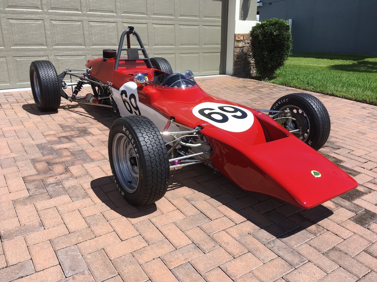 A red race car on a brick surfaceDescription automatically generated